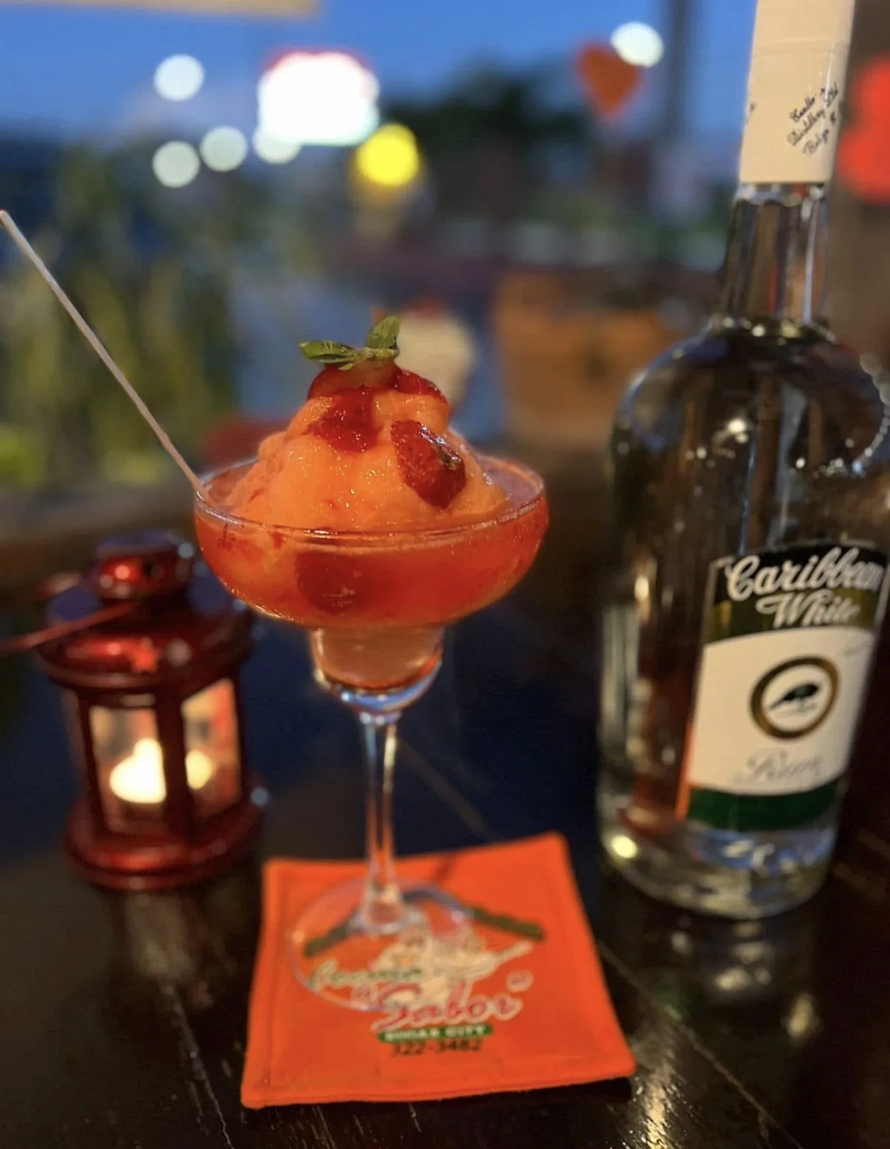 Cocktail with lime and ice beside a bottle of Cuello's Caribbean White Rum