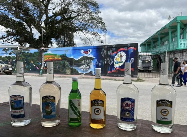 Cuello's bottles in front of an Orange Walk mural